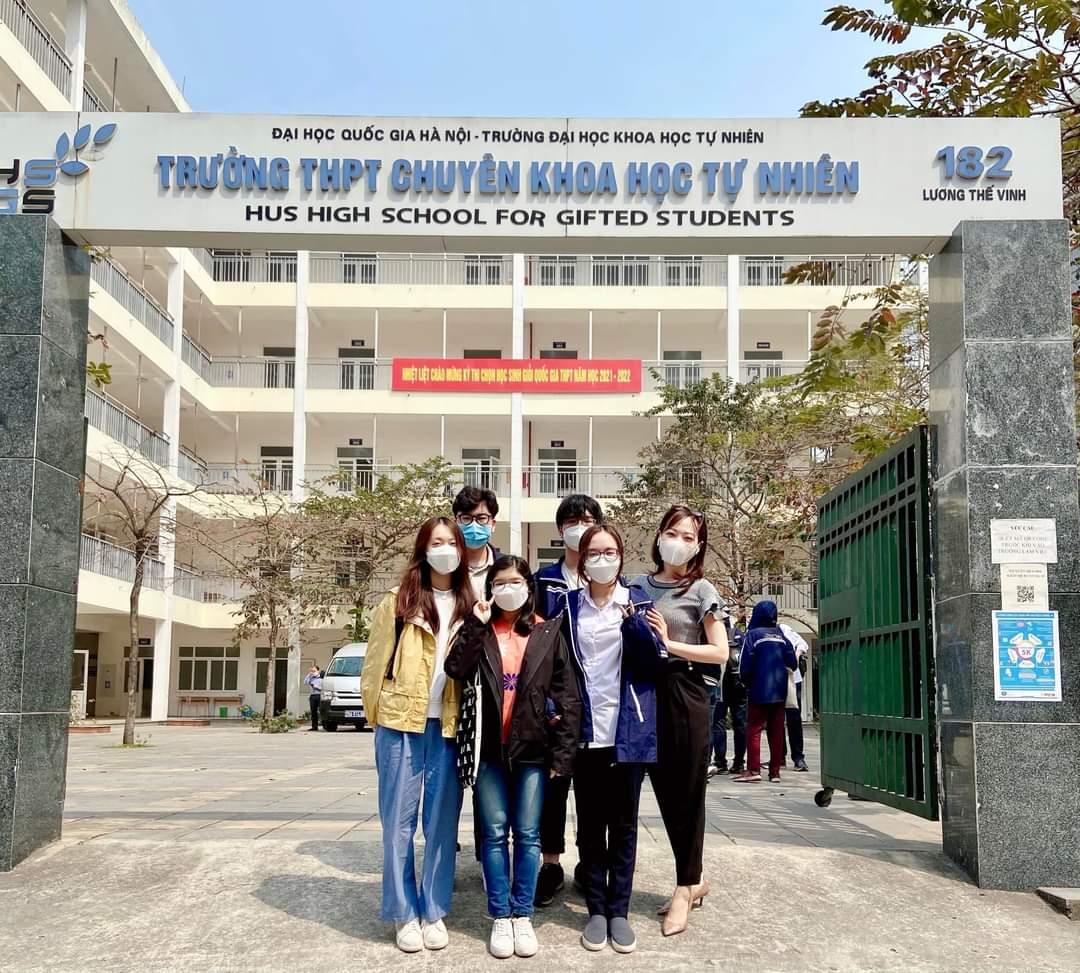A group of people posing for a photo in front of a building</p> <p>Description automatically generated