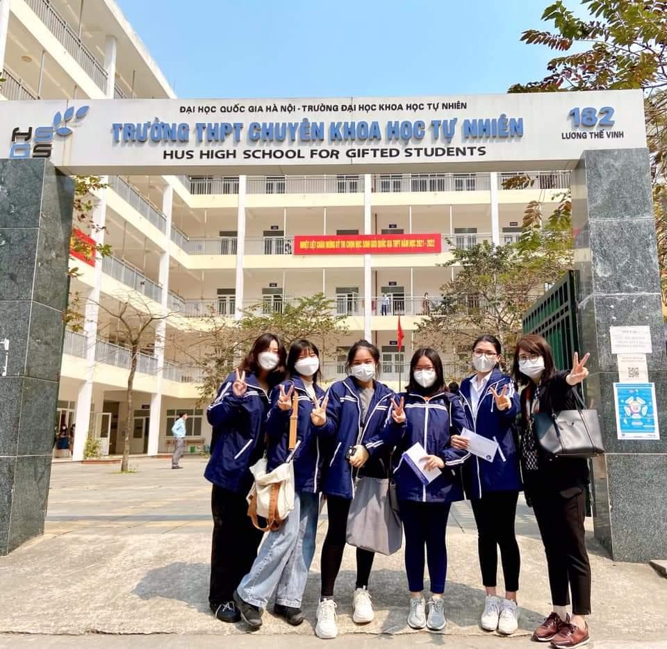 A group of people posing for a photo in front of a building</p> <p>Description automatically generated